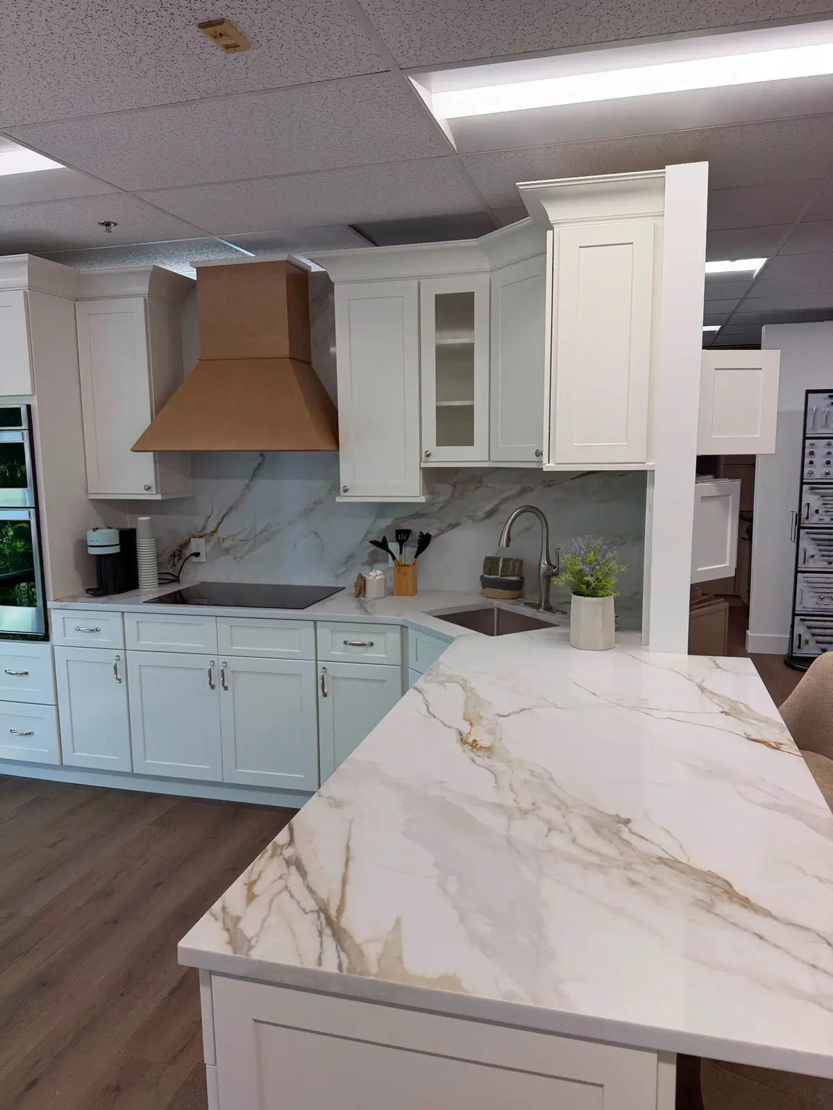 White veined stone countertops and backsplash in a modern white kitchen