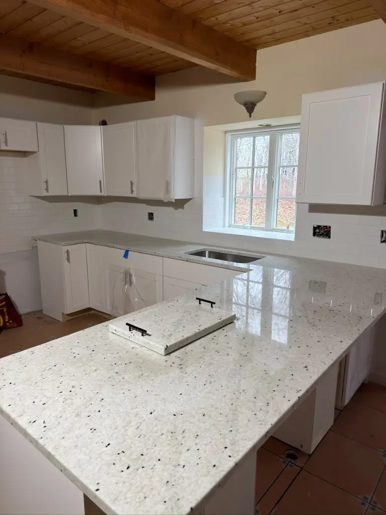 White stone countertops in a residential kitchen project completed by Three Stone