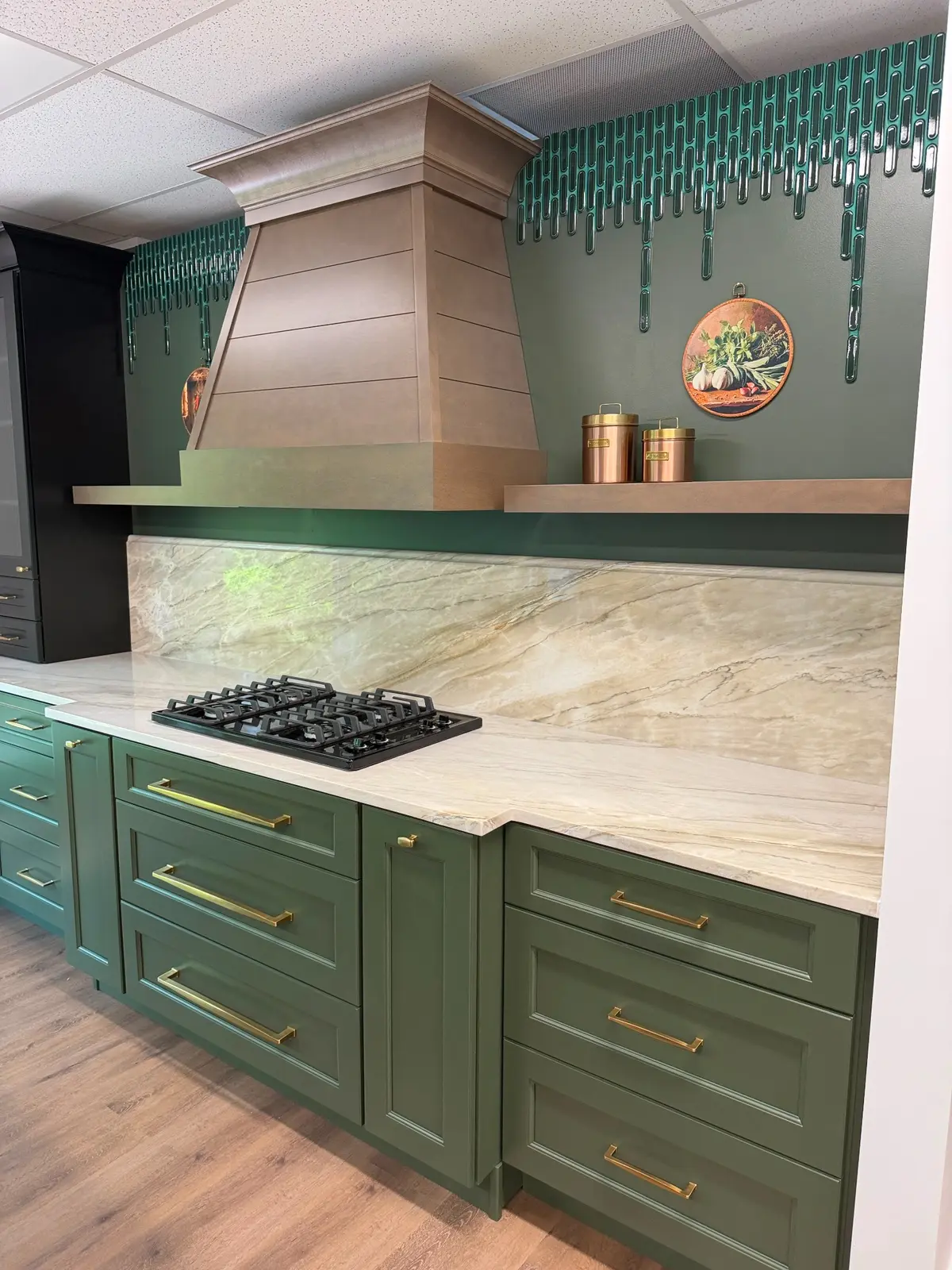 Full height stone backsplash and countertop with green cabinetry